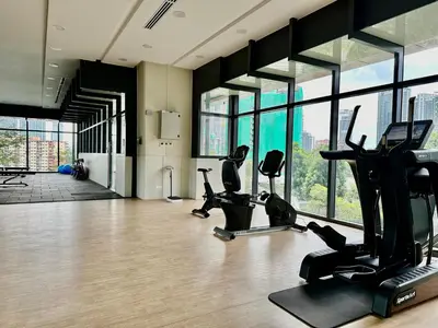 a gym with treadmills and ellipticals in a room with windows at Luxurious Home Smart service Lucentia residence in Kuala Lumpur