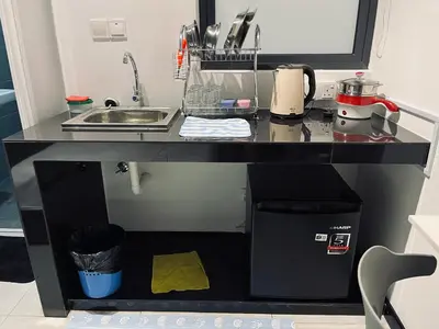 a black kitchen counter with a sink and a microwave at Neu suites 001 cozy studio klcc in Kuala Lumpur