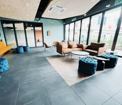 a lobby with couches and tables and windows at Neu suites 001 cozy studio klcc in Kuala Lumpur