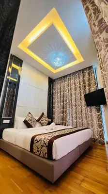 a bedroom with a large bed with a ceiling at The Dorsett Residence Service Suite KL in Kuala Lumpur
