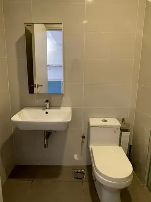 a bathroom with a toilet and a sink and a mirror at CONTINEW Residence - TRX KL in Kuala Lumpur