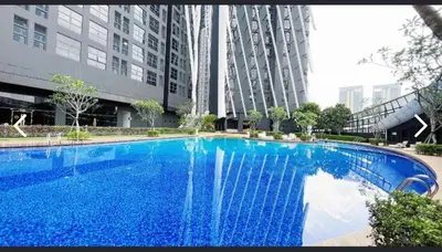 a large blue swimming pool in front of a building at Arte Mont Kiara By ANQ Suites in Kuala Lumpur