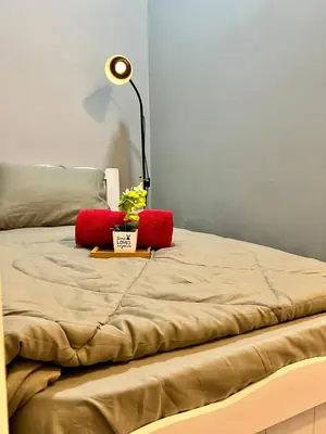 a bed with a lamp and a plant on it at Arte Mont Kiara By ANQ Suites in Kuala Lumpur