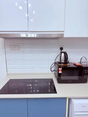 a kitchen with a microwave and a tea kettle on a stove at TRX Continew Residence by Nia in Kuala Lumpur