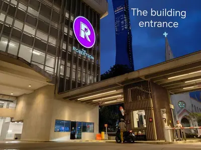 a building with a sign that reads the building entrance at Robertson to be opened in Kuala Lumpur