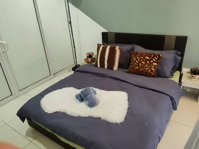 a bed with a blue and white blanket and pillows at Robertson to be opened in Kuala Lumpur