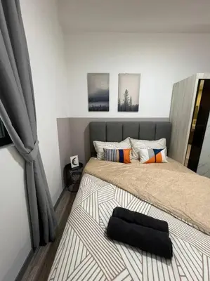 a bedroom with a bed with a black pillow on it at The City Edge United Point in Kuala Lumpur