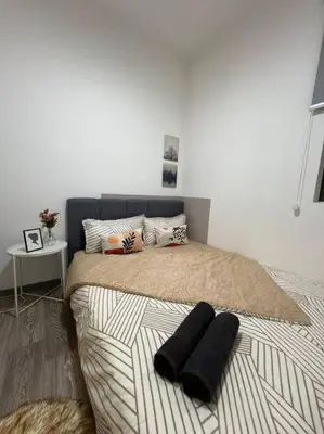 a bedroom with a bed with two black pillows on it at The City Edge United Point in Kuala Lumpur