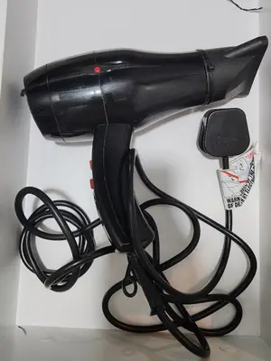 a black hair dryer hanging on a wall at Luxury 4 Bedroom Suite at Cheras Maluri MRT in Kuala Lumpur