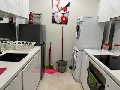 a kitchen with a washing machine and a washer at Vortex Family suites Apartment in Kuala Lumpur
