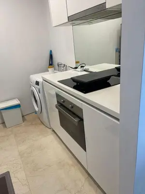 a white kitchen with a stove and a dishwasher at Vortex Family suites Apartment in Kuala Lumpur