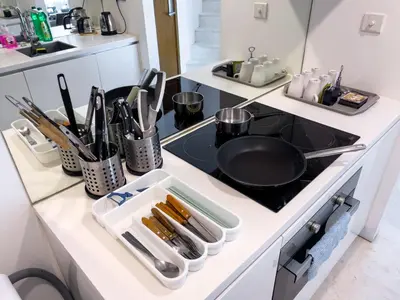 a kitchen counter with a stove with utensils at Luxury Penthouse KLCC & KL TOWER View in Kuala Lumpur in Kuala Lumpur