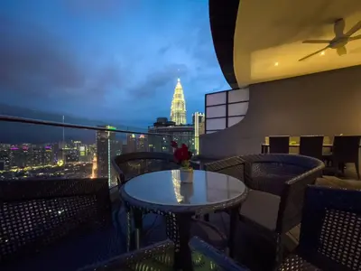 a table on a balcony with a view of the city at Luxury Penthouse KLCC & KL TOWER View in Kuala Lumpur in Kuala Lumpur