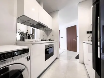 a white kitchen with a washer and dryer at Luxury Penthouse KLCC & KL TOWER View in Kuala Lumpur in Kuala Lumpur