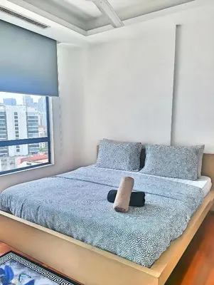 a bedroom with a bed with blue sheets and a window at Casa Residency Apartments and suites KL in Kuala Lumpur