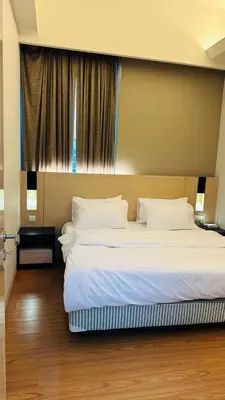 a bedroom with a large bed with white sheets and pillows at SG Residence Kuala Lumpur by Fortune Suites in Kuala Lumpur
