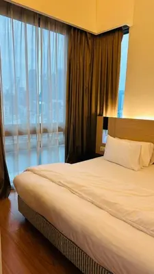 a bed in a hotel room with a large window at SG Residence Kuala Lumpur by Fortune Suites in Kuala Lumpur