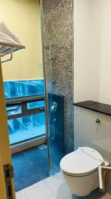 a bathroom with a toilet and a glass shower at SG Residence Kuala Lumpur by Fortune Suites in Kuala Lumpur