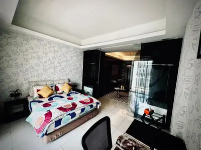 a bedroom with a bed and a chair in it at Damas Hotel,Suites and Residence at Plaza Damas 3 by Over The Moon in Kuala Lumpur
