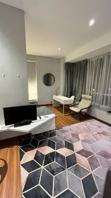 a living room with a couch and a room with a rug at KLCC Apartment in Kuala Lumpur