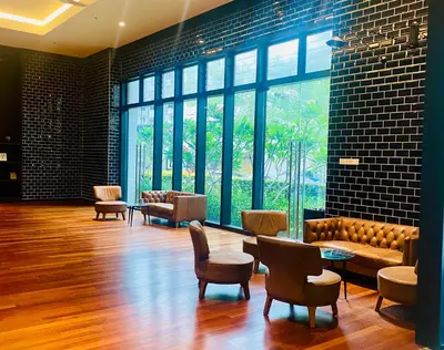 a lobby with a couch and chairs and windows at Chambers Luxury Suites By Zaff in Kuala Lumpur