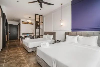 a hotel room with two beds and a ceiling fan at Scarletz Suites KLCC by Luxe Suites in Kuala Lumpur