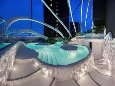 a swimming pool with lights on a building at night at Blue cozy duplex house in Kuala Lumpur