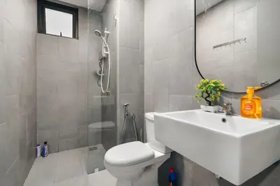 a bathroom with a sink and a toilet and a mirror at IndoChina 3BR MVertica near MRT by RumaBnB in Kuala Lumpur