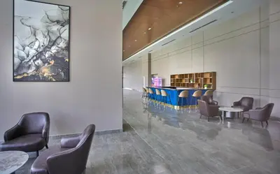 a waiting room with chairs and tables in a building at Trion Residence KL near TRX, MyTown, Ikea Cheras, Pudu in Kuala Lumpur