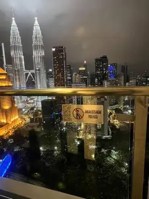 a view of a city at night with a no smoking sign at Legasi High floor 3 BR KLCC view in Kuala Lumpur