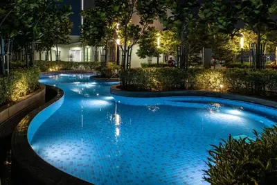 a large swimming pool with blue water at night at Apartment at Robertson by Wgshomestay in Kuala Lumpur