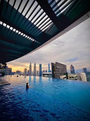 a person in a swimming pool on the roof of a building at Eaton Service Apartment at KLCC in Kuala Lumpur