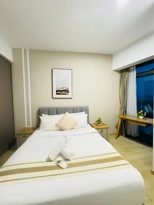 a bedroom with a large white bed and a window at Eaton Service Apartment at KLCC in Kuala Lumpur