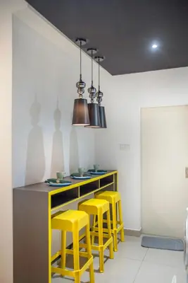 a kitchen with yellow stools and a counter top at Arte Plus Ampang Free Parking in Kuala Lumpur