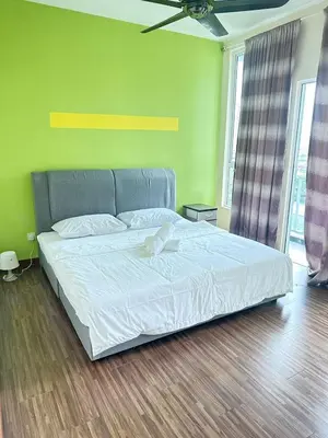a bedroom with a white bed with a green wall at Ubays Zetepark House in Kuala Lumpur