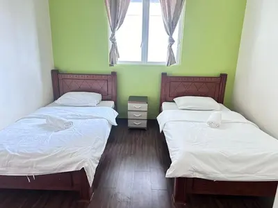 two twin beds in a room with a window at Ubays Zetepark House in Kuala Lumpur