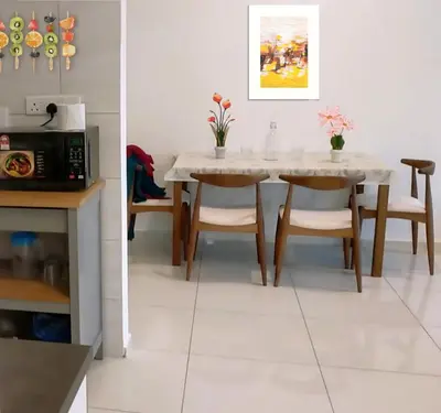 a dining room with a table and chairs and a microwave at The Royal Reside in Kuala Lumpur