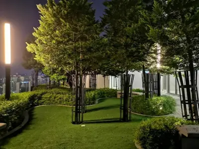 a park with trees and green grass at night at The Royal Reside in Kuala Lumpur