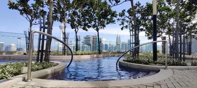 a plunge pool with trees and a city in the background at The Royal Reside in Kuala Lumpur