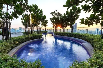 a swimming pool on the roof of a building with trees at The Royal Reside in Kuala Lumpur