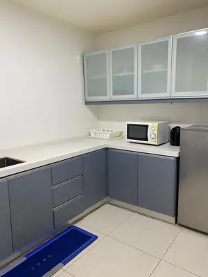 a kitchen with blue cabinets and a microwave at 1 Imbi Suites Times Square Bukit Bintang KL in Kuala Lumpur