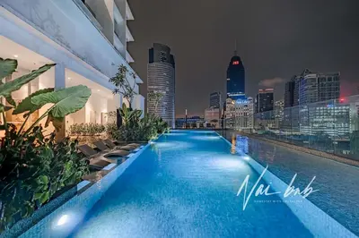 a swimming pool with a city skyline at night at NaiBnB in Quill Residences in Kuala Lumpur