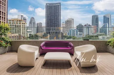 a balcony with two chairs and a purple couch at NaiBnB in Quill Residences in Kuala Lumpur