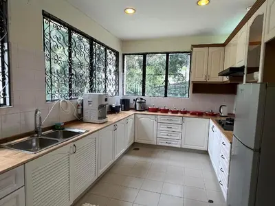 a kitchen with white cabinets and a sink and windows at Bukit Tunku Grande Villa by uBook in Kuala Lumpur
