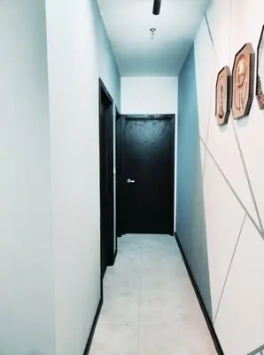 a hallway with a black door and a tile floor at Neu suites cozy 2 bedrooms family house in Kuala Lumpur