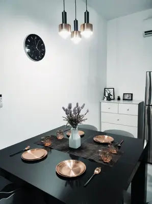 a dining room table with plates and a clock on the wall at Neu suites cozy 2 bedrooms family house in Kuala Lumpur