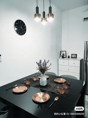 a dining room table with plates and a clock on the wall at Neu suites cozy 2 bedrooms family house in Kuala Lumpur