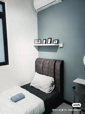 a bedroom with a bed and a shelf with pictures at Neu suites cozy 2 bedrooms family house in Kuala Lumpur