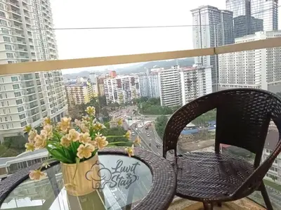 a chair sitting on a balcony with a vase of flowers at Cozy Suite to NEXUS n LifeCare Med in Kuala Lumpur