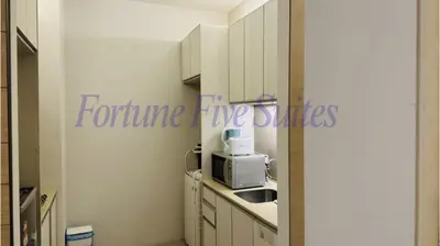 a kitchen with white cabinets and a microwave at SG Residence Kuala Lumpur by Fortune Suites in Kuala Lumpur